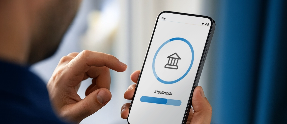 Blog RecargaPay | Entenda por que é importante manter seu app financeiro atualizado Celular com tela atualizando na mão de uma pessoa