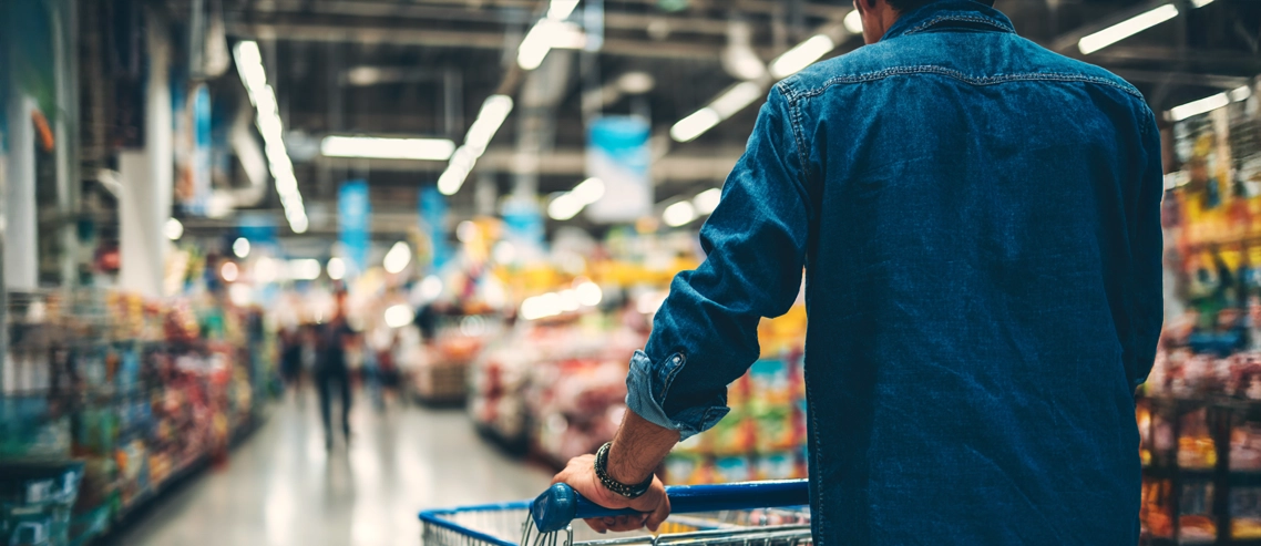 Pessoa fazendo compra com carrinho no supermercado